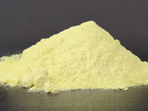 A heap of powdered sulphur on a dark surface
